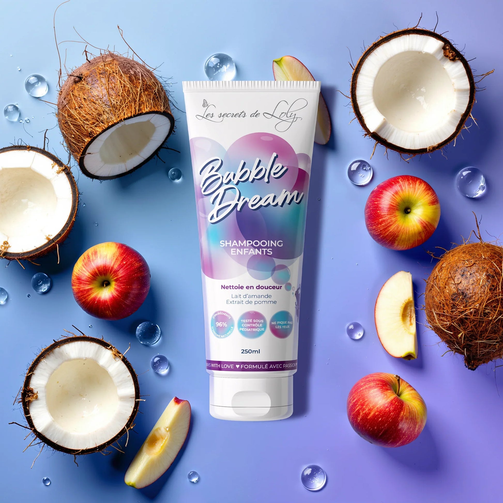 Children’s shampoo tube with apples, coconut halves, and water drops on blue background.