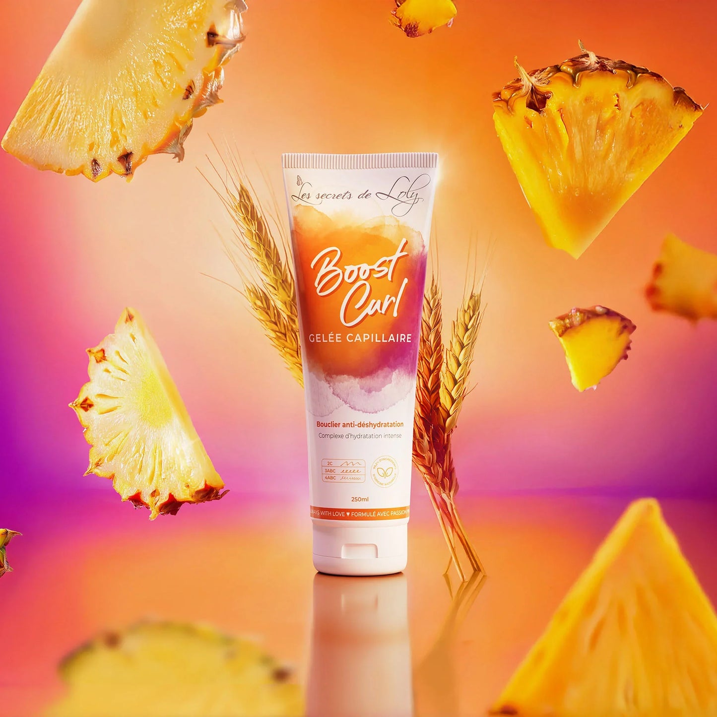 Boost Curl hair gel tube with wheat stalks and pineapple slices on an orange background