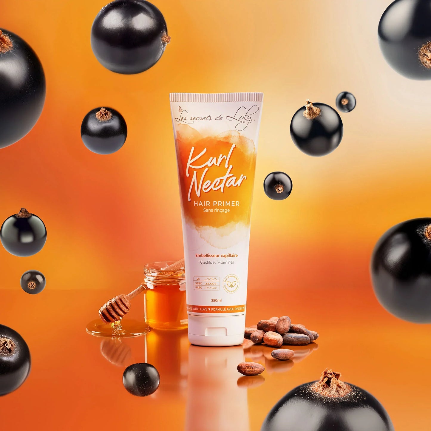 Kurl Nectar hair primer tube with honey, blackcurrants, and cocoa beans on an orange background