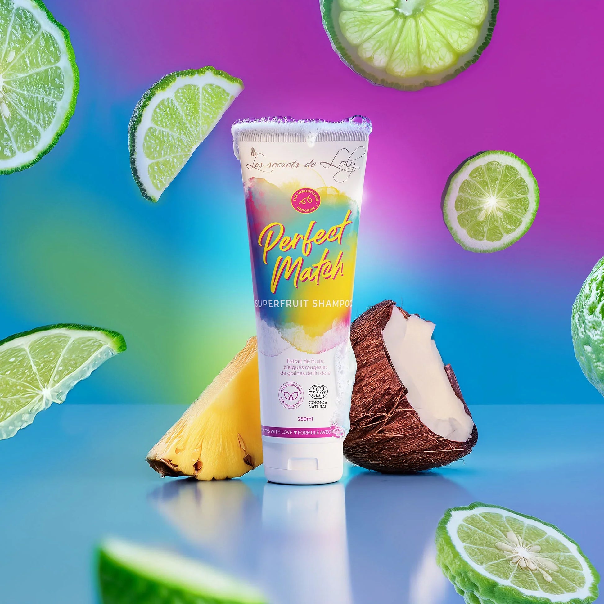 Colorful superfruit shampoo tube with fresh lime, coconut, and pineapple on a vibrant background