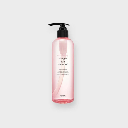 Pink bottle of raspberry vinegar hair shampoo with pump dispenser on white background